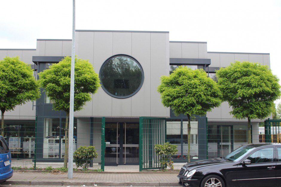 Gewerbebau: zweigeschossiges Büro- und Gewerbegebäude mit heller Paneelfassade und großem Rundfenster